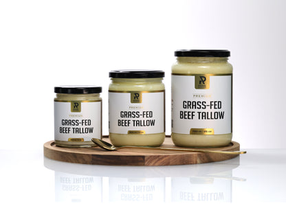Three jars of grass-fed beef tallow on a wooden tray with a white background