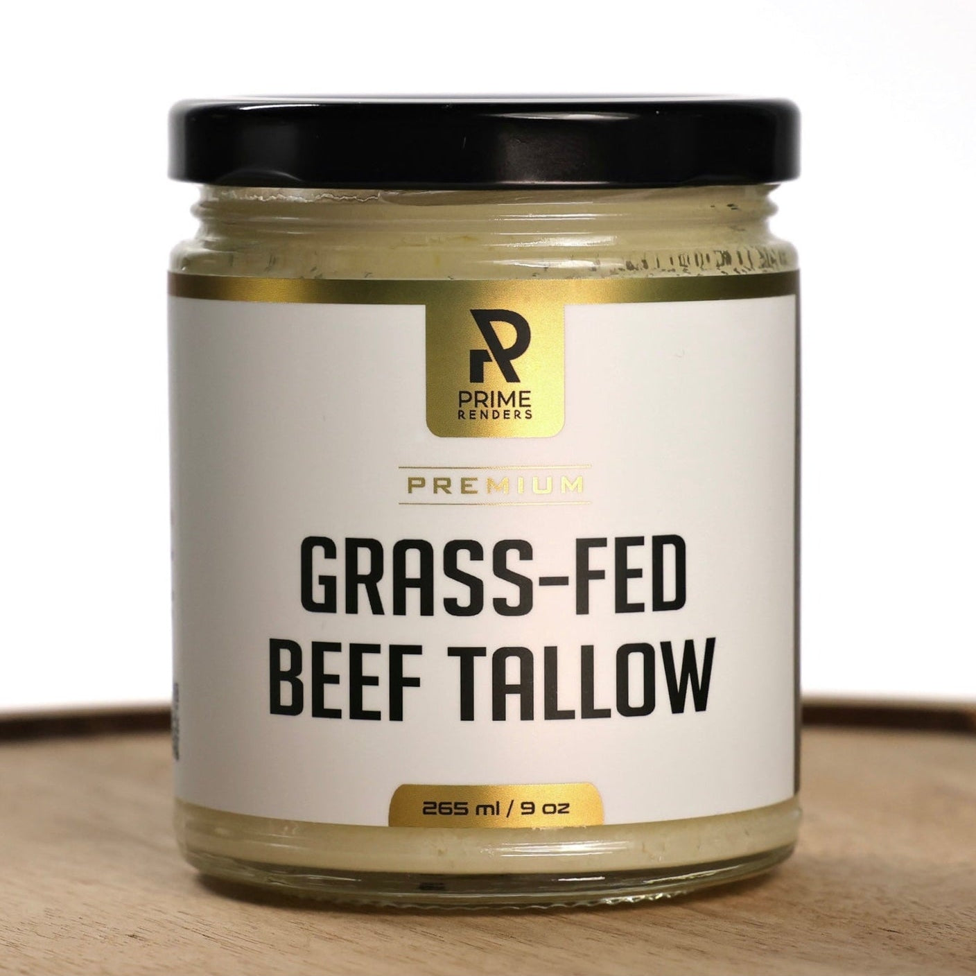 Jar of grass-fed beef tallow with a Prime Renders brand label on a wooden surface.