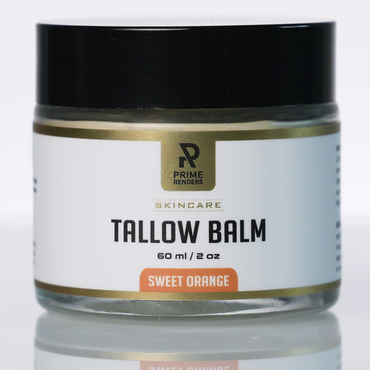 A jar of Prime Renderers Tallow Balm in Sweet Orange scent, featuring a black lid and a white label with gold and orange accents, set against a clean white background with a soft reflection below.