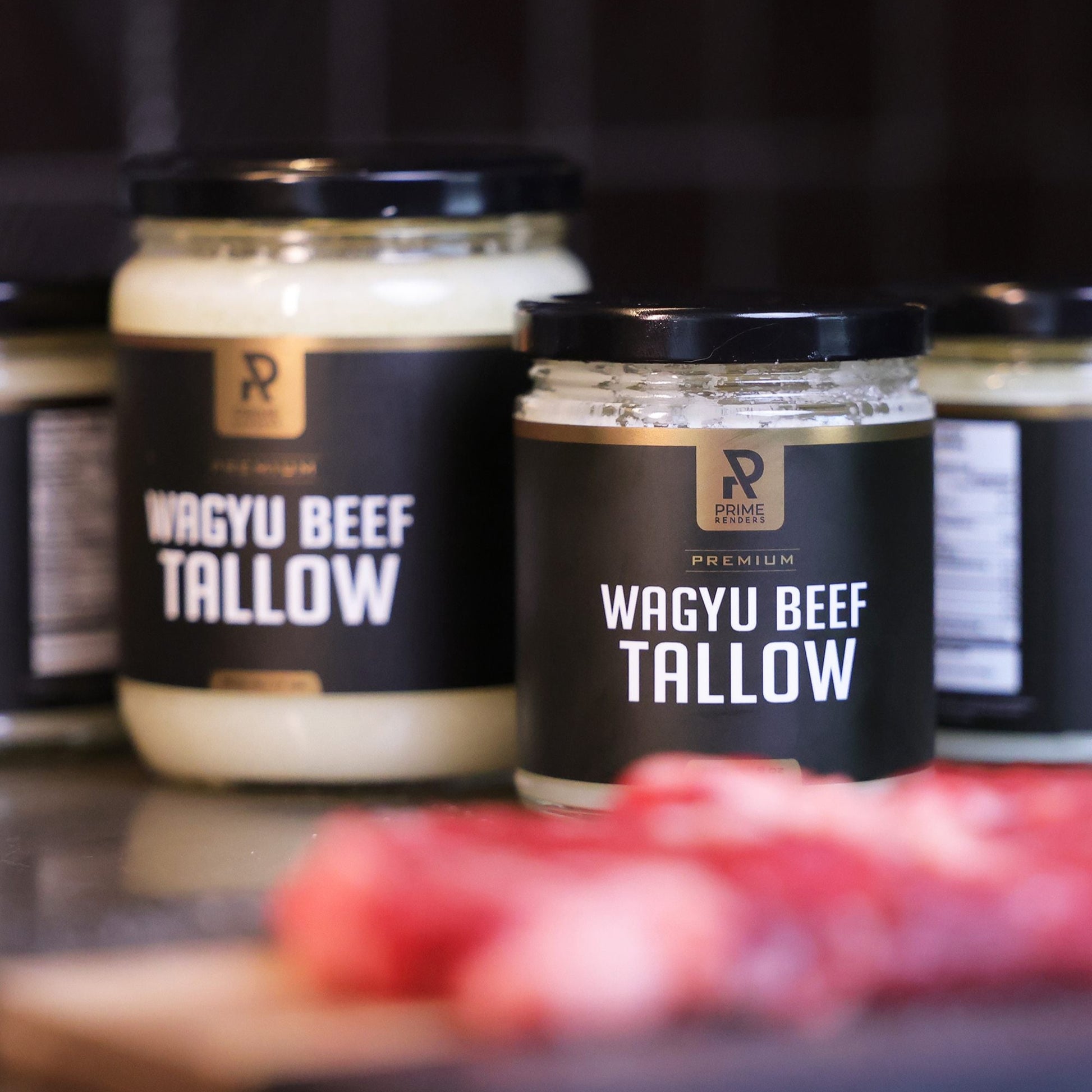 Jars of wagyu beef tallow with visible branding on a dark background